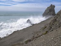 the waves hit rocks near the shore of the water's edge and crash on it