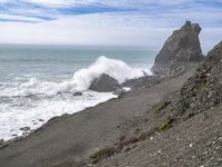 the waves hit rocks near the shore of the water's edge and crash on it