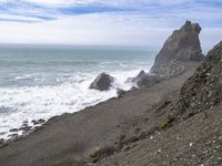 the waves hit rocks near the shore of the water's edge and crash on it