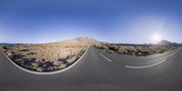 an image of two identical panoramas of a long road in the desert with the sun