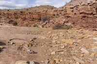 the jeep is parked near the rocky hill of rocks and dirts in the desert