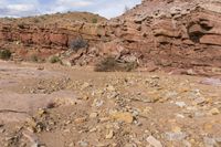 the jeep is parked near the rocky hill of rocks and dirts in the desert