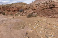 the jeep is parked near the rocky hill of rocks and dirts in the desert