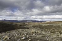 the dirt is full of rocks and boulders under the sky in the mountains above the hills