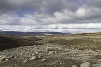 the dirt is full of rocks and boulders under the sky in the mountains above the hills