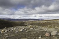 the dirt is full of rocks and boulders under the sky in the mountains above the hills