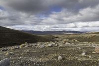 the dirt is full of rocks and boulders under the sky in the mountains above the hills