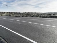 a deserted street in the middle of nowhere on a clear day with blue sky and clouds