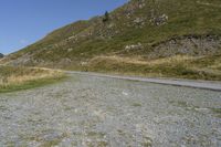 a motorcycle parked on a small mountain side road near mountains with no cars driving on it