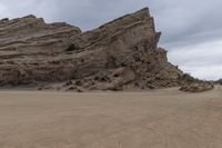 the road is made up of large mountains and sand dunes with two motorcycles parked in front