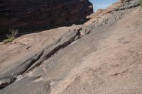 two birds that are sitting on some rocks by itself in the desert on a sunny day