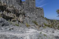 some very large rocky formations with rocks in the back ground and trees and grass on both sides