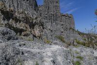 some very large rocky formations with rocks in the back ground and trees and grass on both sides