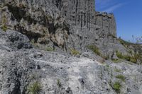 some very large rocky formations with rocks in the back ground and trees and grass on both sides