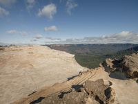 a hiker pauses to take in the view from the top of a cliff at blue mountains state park