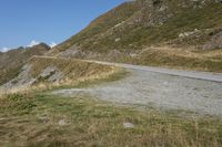 a motorcycle parked on a small mountain side road near mountains with no cars driving on it