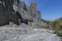 a rocky cliff face is seen from a high angle with no one visible on it