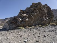 a rocky outcropping in the middle of nowhere with a clear sky above