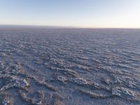 the desert floor is a lot of sand and dirt all around it, and the ground is mostly white and there are no one visible