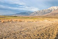 an open desert plain with a big mountain in the background and some dirt on the ground