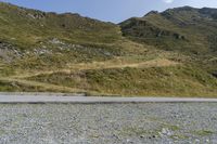 a motorcycle parked on a small mountain side road near mountains with no cars driving on it