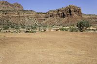 an outback car parked at a corner of a desert road with steep cliffs in the background