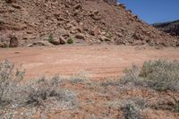 a hill with rocks and dirt in the area with an object in it in front of a blue sky