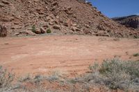 a hill with rocks and dirt in the area with an object in it in front of a blue sky