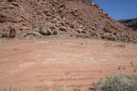 a hill with rocks and dirt in the area with an object in it in front of a blue sky