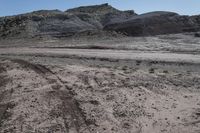 a barren and muddy landscape with rocks, rocks, dirt, dirt and grass on the ground