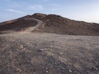 a truck on a dirt road in the desert with rocks and stones on the ground