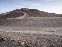 a truck on a dirt road in the desert with rocks and stones on the ground