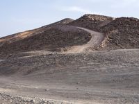 a truck on a dirt road in the desert with rocks and stones on the ground