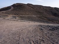 a truck on a dirt road in the desert with rocks and stones on the ground