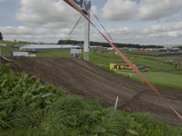 several race signage and dirt bike course on a hill side under clouds on a cloudy day