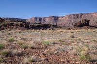 the mountains rise from the ground and brown, brown, and green terrain in front of them