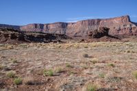 the mountains rise from the ground and brown, brown, and green terrain in front of them