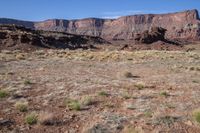 the mountains rise from the ground and brown, brown, and green terrain in front of them