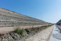 road with rocky hill with sand and water in the distance on it's side