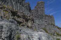 the man is riding a bike down the hill on a trail lined with steep cliffs