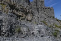 the man is riding a bike down the hill on a trail lined with steep cliffs