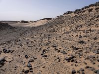 a truck on a dirt road in the desert with rocks and stones on the ground