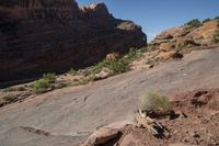 a man hiking up a big rocky cliff, on the trail down to the falls