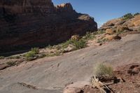 a man hiking up a big rocky cliff, on the trail down to the falls