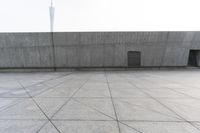 a large gray building with some concrete walls and a closed door in it's center