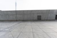 a large gray building with some concrete walls and a closed door in it's center