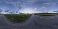 the 360 view lens is seen in an image above a road with grass and hills