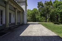 the walkway is empty in front of the house and trees in the background on a sunny day