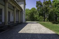 the walkway is empty in front of the house and trees in the background on a sunny day