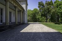 the walkway is empty in front of the house and trees in the background on a sunny day